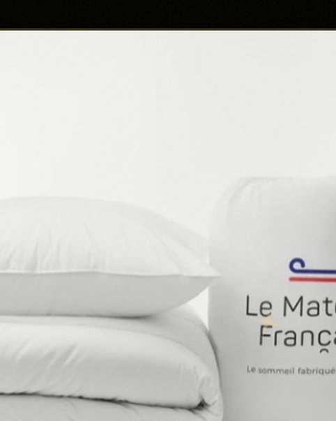 White bedding set — duvet, pillows and a carry bag printed with "Le Matelas Français"