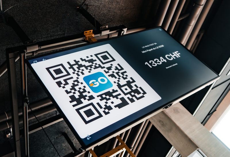 The GoTombola Live Wall screen during the LS gala: a large QR code to scan and a real-time fundraising counter.
