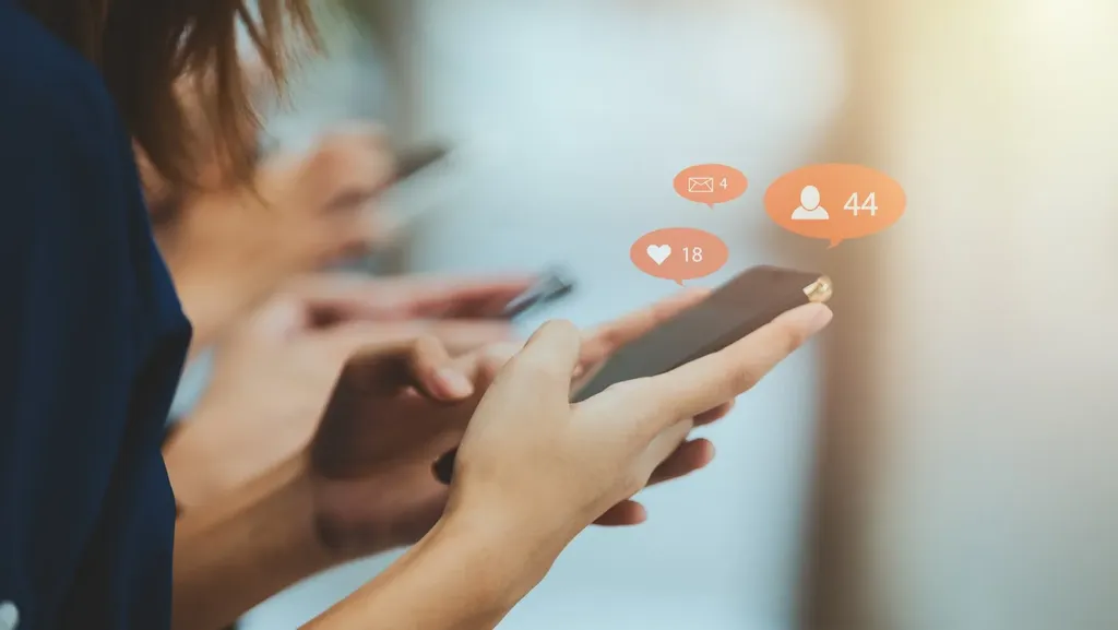 Three people side by side look at their smartphones; notification bubbles show messages, likes and new followers.